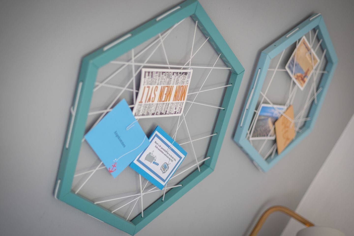 En vägg med hexagonformade ramar som innehåller olika papper och ett blått kuvert.