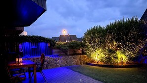 A patio area with a stone wall, a wooden table, and chairs. - Christopher, App. 6 Strönhüs - Urlaubsfeeling Pur. Mit Äußerst Viel Liebe zum Detail (Wenningstedt-Braderup (Sylt))
