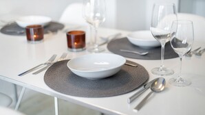A modern dining table set with white plates, clear glasses, and a candle. - Badezeit - Verbringen Sie Ruhige Tage in Modernem, Designorientiertem Ambiente (Wenningstedt-Braderup (Sylt))