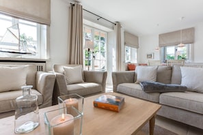 A modern living room with two sofas, a coffee table, and a bookshelf.