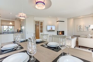 Ein modernes Wohnzimmer mit Essbereich, gedeckt für eine Mahlzeit.