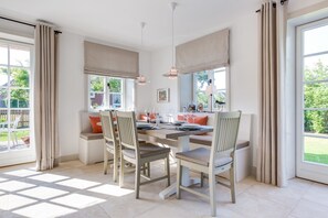 A dining area with a table set for four, two chairs on each side, and a bench with cushions. - Marysol - Erleben Sie Ihren Urlaub im Typischen Sylt-stil Unter Reet (Wenningstedt-Braderup (Sylt))