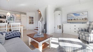 Un amplio espacio habitable con una escalera, zona de comedor y cocina.