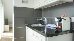 A compact kitchen with a Bosch dishwasher, a sink, and a coffee maker. - Wallhof, App. 6 - Urlauben und Relaxen im Haus Wallhof - Genießen Sie Sylt in Vollen Zügen (Wenningstedt-Braderup (Sylt))