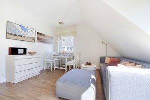 Un dormitorio tipo loft moderno con comedor, muebles blancos y vista al cielo.