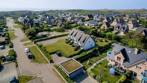 A residential area with houses, a large grassy field, and a road. - Landhaus Westerhörn, Sölring Tir, App. 1 - Beste Lage Zwischen Meer und Dorfteich. Sehr Schöne (Wenningstedt-Braderup (Sylt))