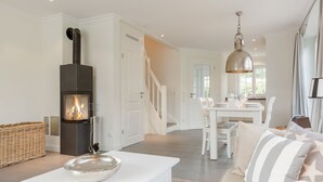 Ein modernes Wohnzimmer mit Kamin, Essbereich und Wendeltreppe.