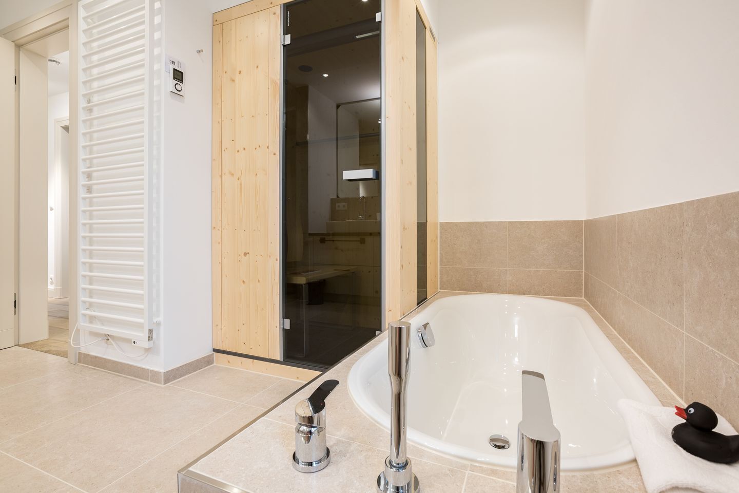 A modern bathroom with a freestanding bathtub, a towel rack, and a shower area.