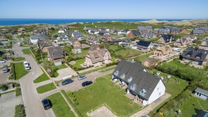An aerial view of a residential area with houses, roads, and a beach in the background. - Sylter Refugium, App. 2 - Mitten im Beliebten Inselort Wenningstedt Befindet Sich Dieses Appartement (Wenningstedt-Braderup (Sylt))