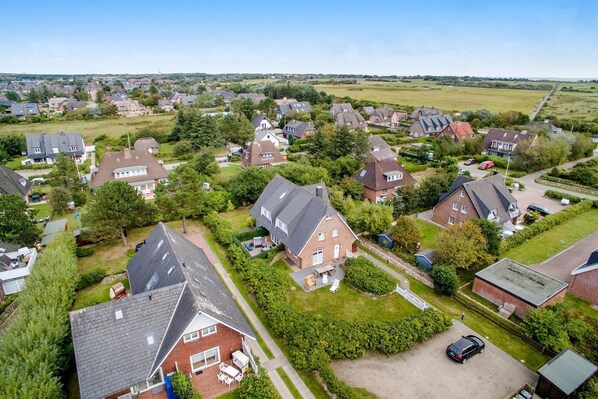 A residential area with houses, lawns, and a clear sky.