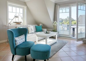 A modern living room with a sofa, two armchairs, a coffee table, and a large sliding glass door leading to a balcony. - Zita, App.8 - Dorfteich. Dünen. Erholung (Wenningstedt-Braderup (Sylt))