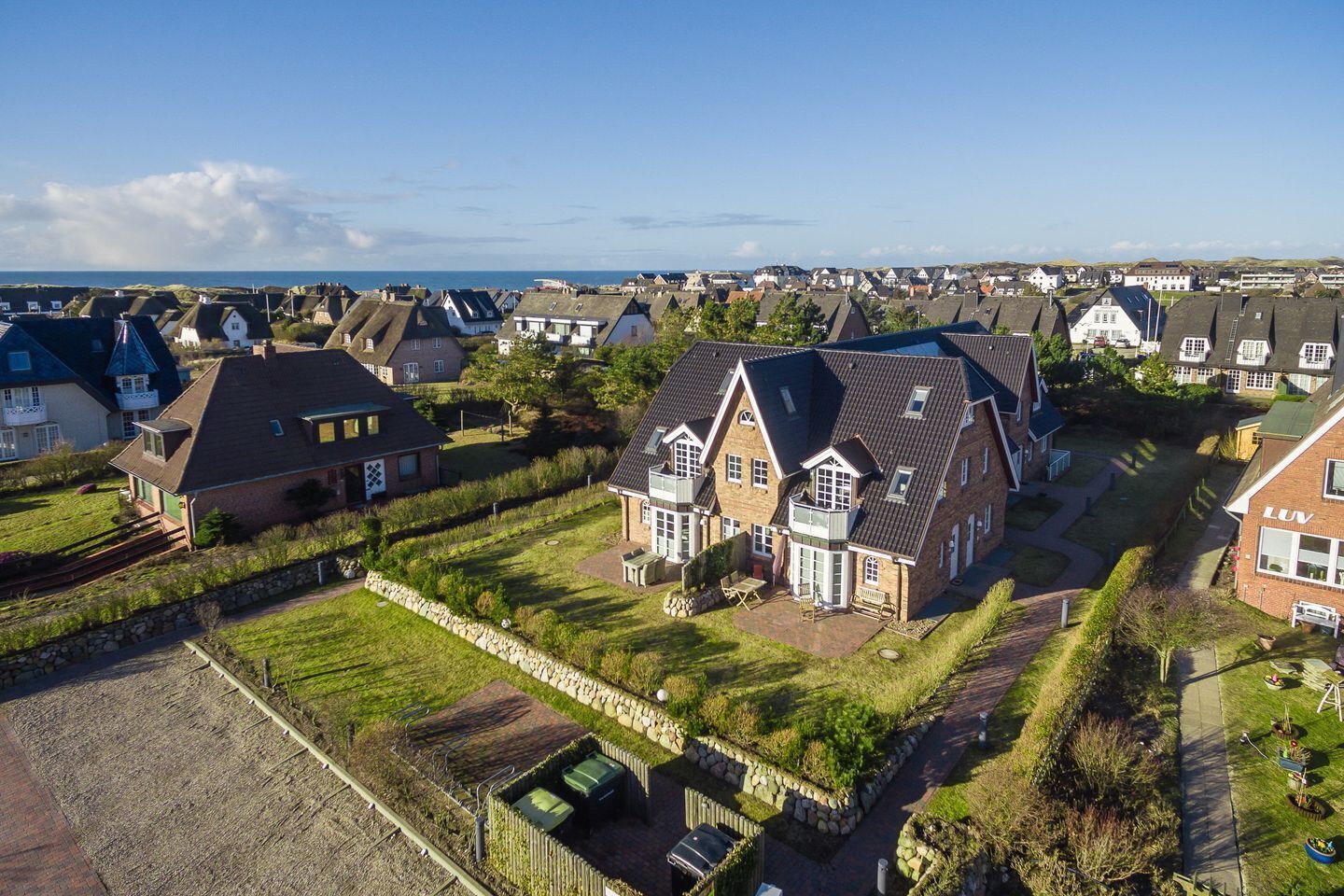 Een woonwijk met huizen met puntige daken en een stenen muur.