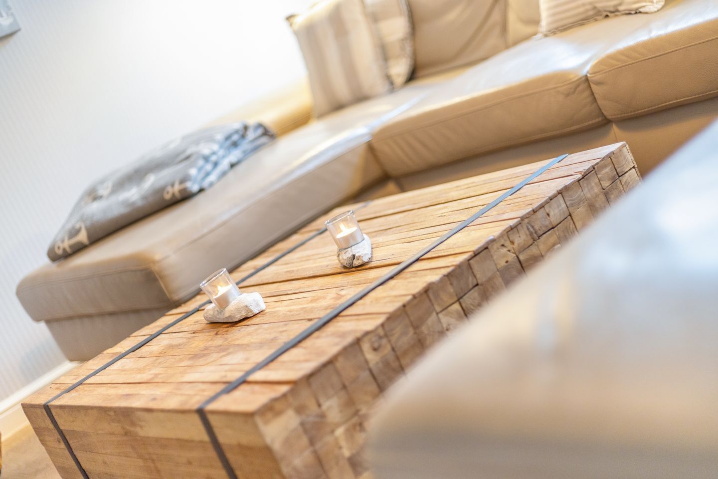 Una sala moderna con una mesa de centro de madera, un sofá y un cojín.