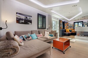 A modern living room with a sofa, a coffee table, and a fireplace.