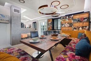 Un espace repas moderne avec une table en bois, des chaises et un canapé coloré.