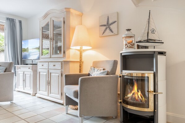 Una sala de estar acogedora con chimenea, televisor y vistas al exterior.