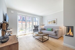 Ein modernes Wohnzimmer mit einer Couch, einem Couchtisch und einem Kamin.