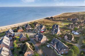 En kustby med traditionella hus, en strand och en fri utsikt över havet.