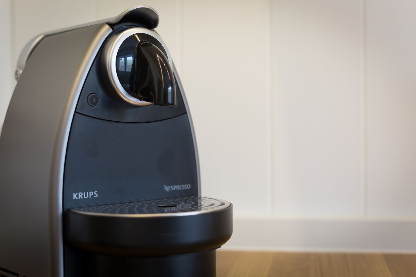 A Krups Nespresso coffee maker with a control panel and a water reservoir.