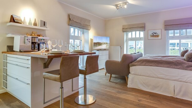 Une chambre moderne avec un lit, un bureau et une chaise, un canapé et un téléviseur.