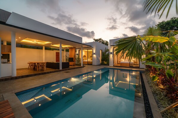 A modern house with a swimming pool, outdoor seating, and a covered patio area. - Villa Selikur 1  (Seminyak)