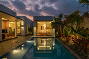 A modern house with a swimming pool, a bedroom with a large bed, and a well-lit entrance. - Villa Selikur 1  (Seminyak)
