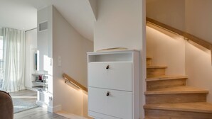 Un intérieur moderne avec un escalier, un meuble blanc et un coin cuisine.