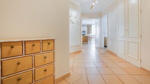 A hallway with a wooden dresser, white doors, and a tiled floor. - Nette-star, App. 14 - Einmalige Lage. Fantastischer Wellnessbereich. Viel Platz und Stil für Zwei (Sylt)