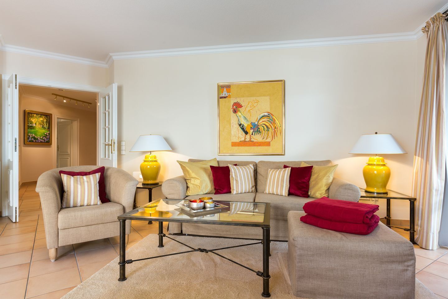 A living room with a sofa set, two lamps, a coffee table, and a painting on the wall.