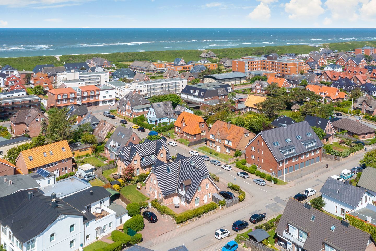 Ein Küstenwohngebiet mit einer Mischung aus moderner und traditioneller Architektur, das verschiedene Hausstile aufweist und eine markante Meerblick bietet.