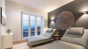 Une chambre moderne avec une grande fenêtre, un élément décoratif rond fixé au mur et une petite table ronde.