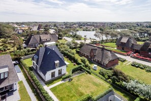Et boligområde med huse, en sø og en velholdt græsplæne.