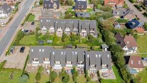 Zona residencial con varias casas, una calle y espacios verdes.