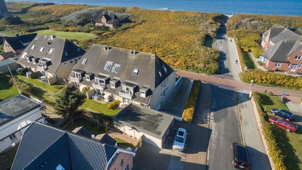 A coastal residential area with houses, a road, and a view of the sea. - Beachhouse Lornsen-hof, App 7 - Lage, Lage, Lage! Das Beachhouse Lornsenhof Müssen Sie Einfach (Sylt)