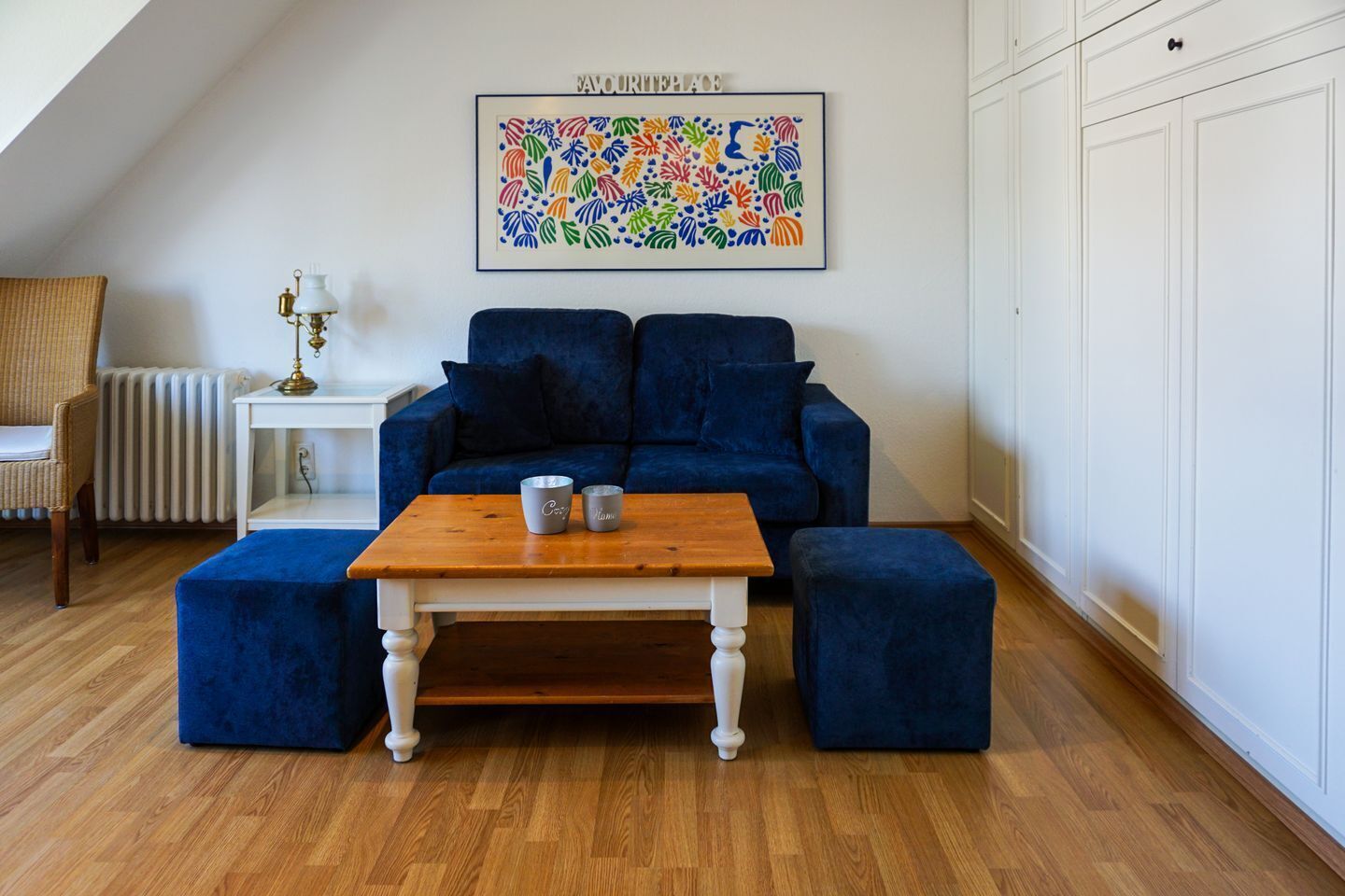 A cozy living room with a blue sofa, a wooden coffee table, and a radiator.
