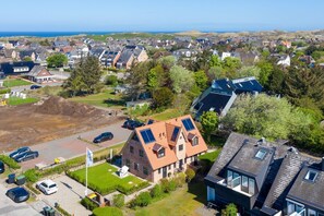 A residential area with houses, a paved driveway, and a clear view of the sea. - Lille Wung - Ruhige und Dennoch Zentrale Lage? (Wenningstedt-Braderup (Sylt))