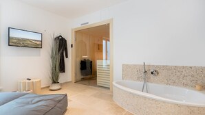 Uma casa de banho moderna com uma banheira independente, chuveiro e um espelho grande.