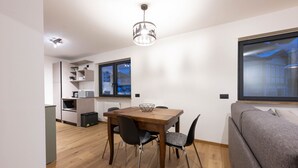 Et moderne køkken med spiseplads, en sofa og et stort vindue.