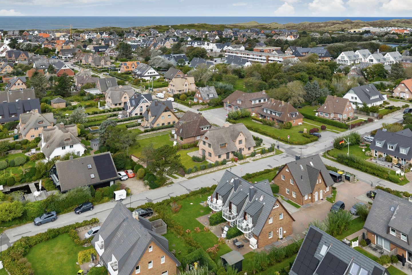Área residencial com casas, ruas e vista para o mar.