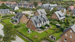 Ein Wohngebiet mit Häusern, die Satteldächer und mehrere Stockwerke haben.