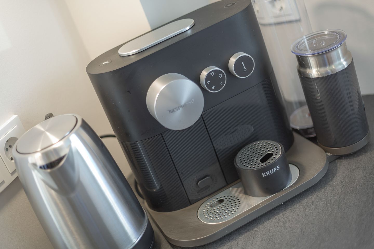 Una máquina de café con jarra, cafetera y molinillo de café Krups sobre una encimera.