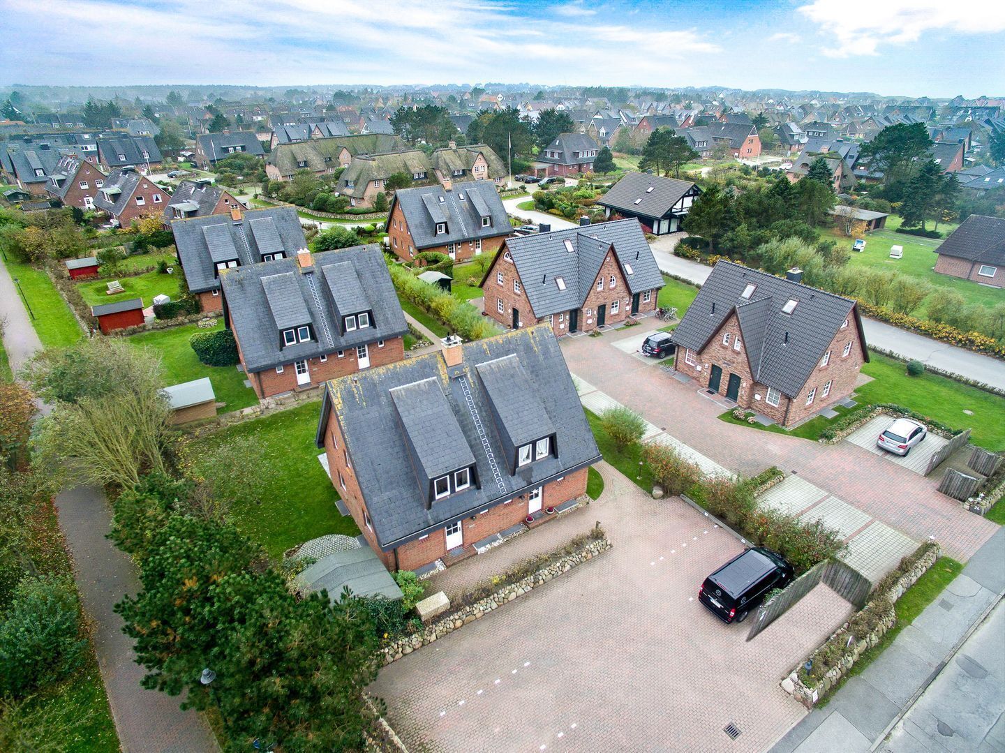 A residential area with houses featuring pitched roofs and brick construction.
