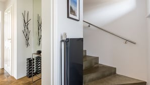 Ein modernes Interieur mit Treppe, gerahmtem Bild und abstrakter Wandkunst.