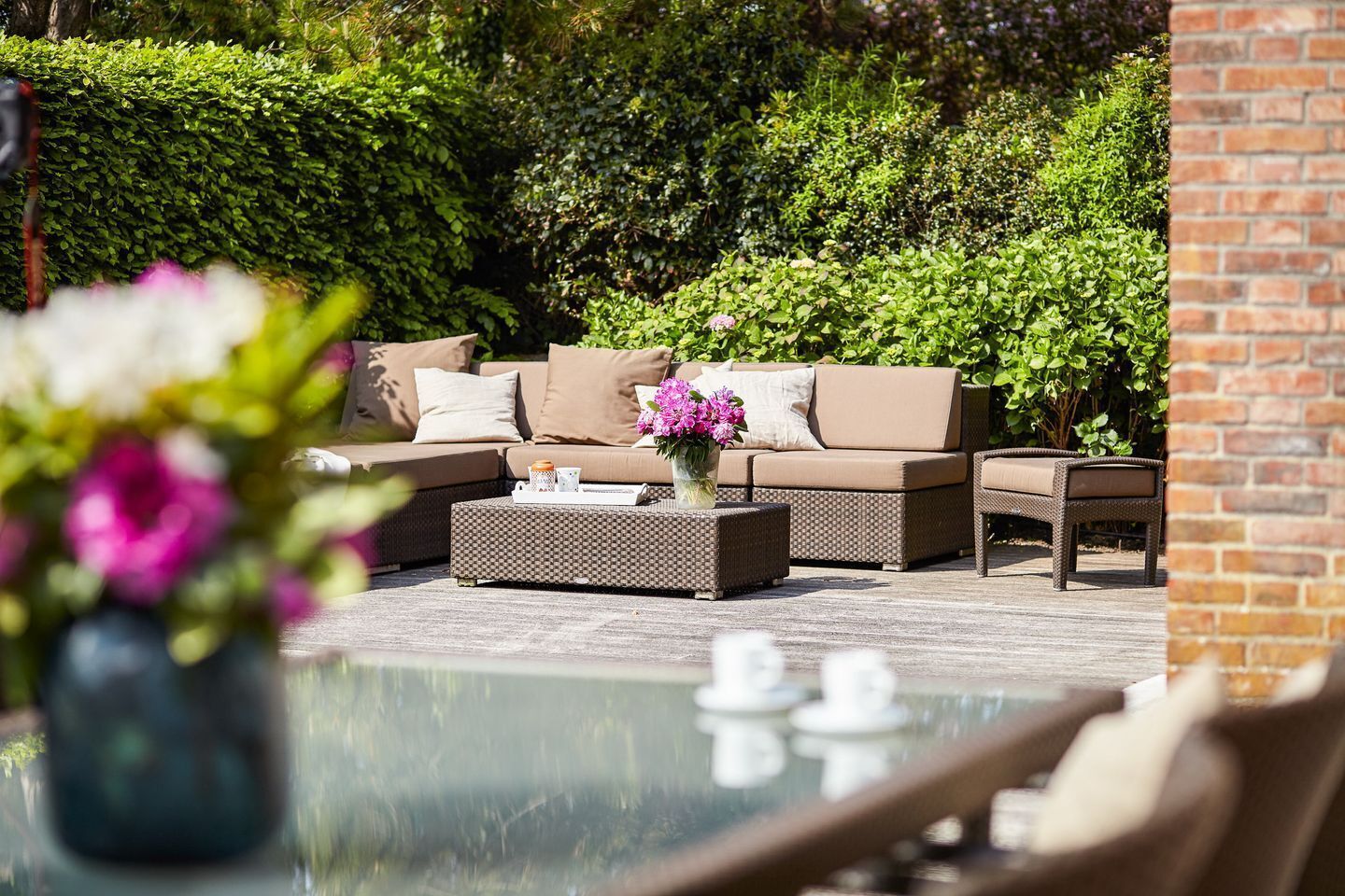 An outdoor seating area with a sofa, a coffee table, and a chair.
