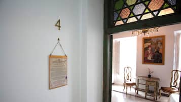 Una habitación con un escritorio de madera, dos sillas, un cuadro en la pared y un cartel con el número 4.