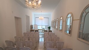 Un vaste hall doté de rangées de chaises, d’un lustre et de fenêtres en arc de cercle.