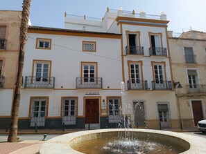 Un edificio llamado "EL PALACETE" con una fuente en su fachada.