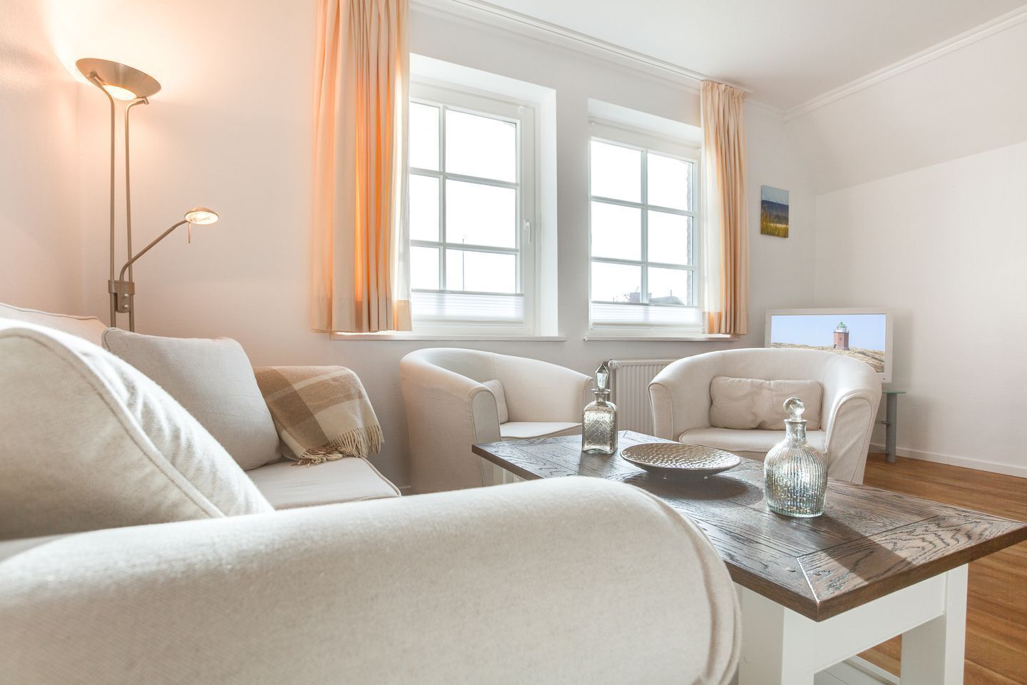 Ein modernes Wohnzimmer mit einer Sofagarnitur, einem Couchtisch und einem Fernseher.