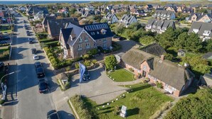 An aerial view of a residential area with houses, a parking lot, and a flag.