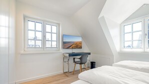 A bedroom with a desk, a chair, and a bed. - Fitte Huck - Hausteil mit ca. 95qm Nutzfläche im EG, UG, OG und DG (Hörnum (Sylt))